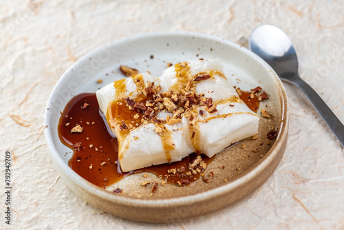 A photo of a plate of mochi with brown sugar syrup and crushed peanuts.