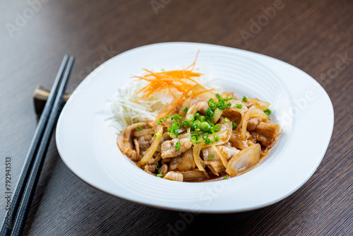 A plate of food with pork, onions, and carrots.