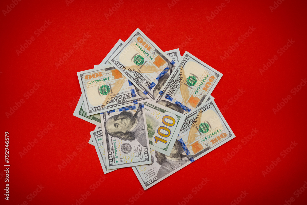 a pile of old and new dollars on a red background.