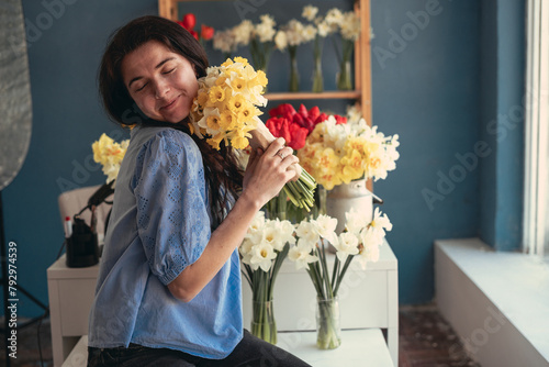 Portrait of a happy woman with a bouquet of flowers in her hands. Florist working in a flower shop
