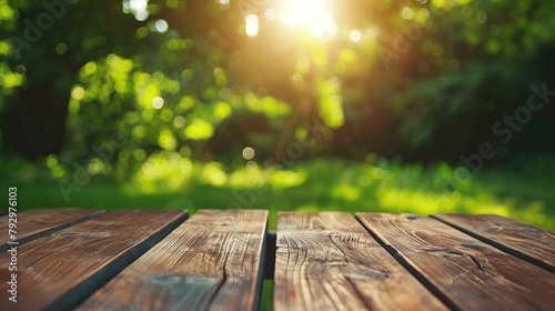 An empty wooden table with a blurred background of green leaves and sunlight.