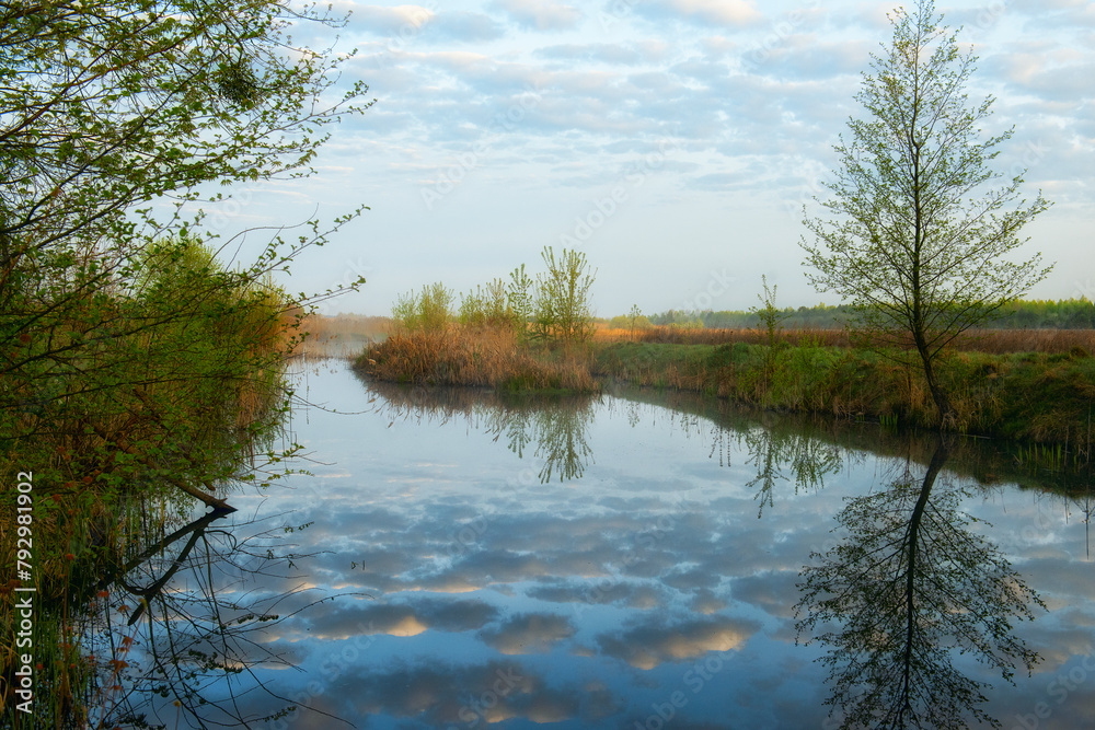 Obraz premium Spring river. reflection of clouds in water.