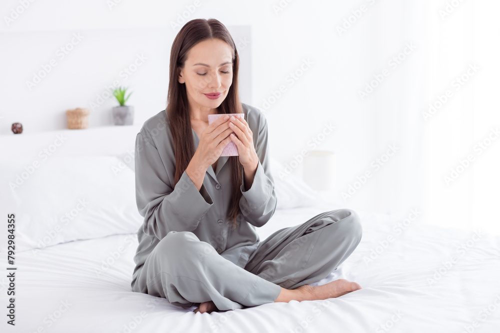 Photo of adorable pretty lady wear grey nightwear drnking coffee sitting bed indoors apartment bedroom Photo of adorable pretty lady wear grey nightwear drnking coffee sitting bed indoors apartment bedroom