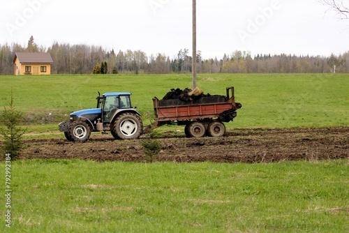 agricultural machinery spreads manure on the field in spring