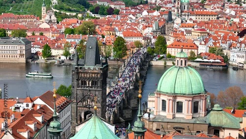 Charles Bridge is a medieval stone arch bridge that crosses the Vltava river in Prague, Czech Republic. Its construction started in 1357 under the auspices of King Charles IV. photo
