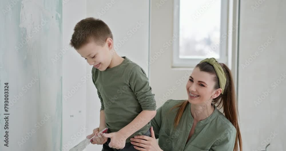 A heartwarming scene of a family during a home renovation. This image captures a mother embracing her son in a partially painted room, surrounded by renovation tools and materials