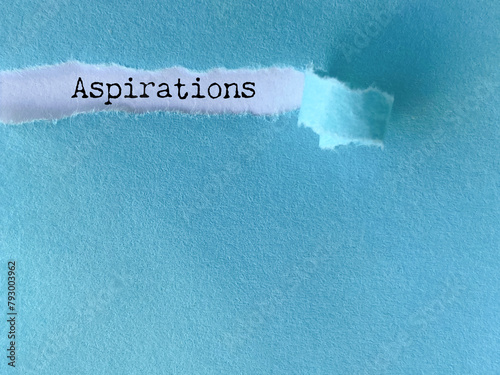 Inspirational Quote - aspirations text behind torn paper background. Stock photo.