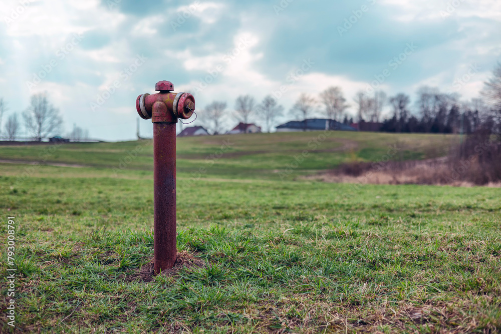 Rusty fire hydrant in a field with green grass. Rusty fire hydrant in a field with green grass.
