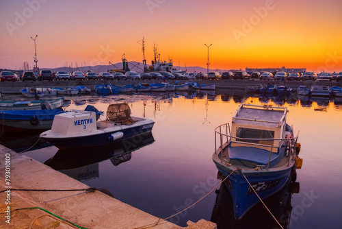 sozopol, bulgaria - 03 sep 2019: small fishing boats in the harbor at dusk. cloudless sky reflecting in the water