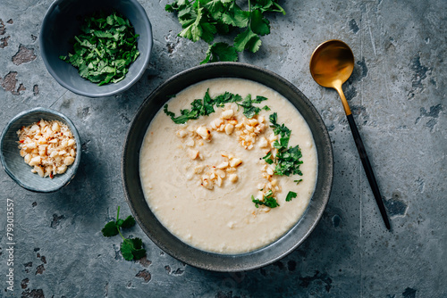 Spicy and creamy cauliflower and coconut soup with cilantro and macadamia nuts