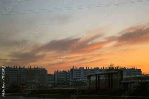 Multi-storey buildings at dusk and clouds in the evening sky at sunset