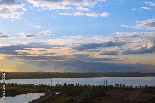 Beautiful cloudy scenery over the lake and the city at sunset at dusk