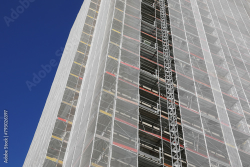 skyscraper with scaffolding during the installation of panels for thermo-acoustic insulation photo