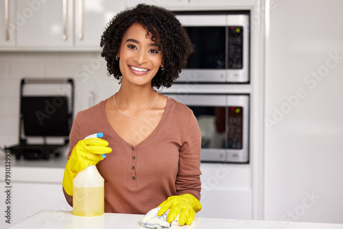 Black woman, portrait and cleaning counter in kitchen, wipe glass and spray chemicals for hygiene. Female person, maid and maintenance service in apartment, soap and disinfection detergent to tidy photo