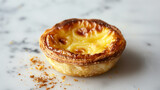 Indulge in the creamy delights of our Custard Tart, known as Pastel de Nata, elegantly presented against a refined grey background. Originating from Portugal, this delectable pastry boasts a rich