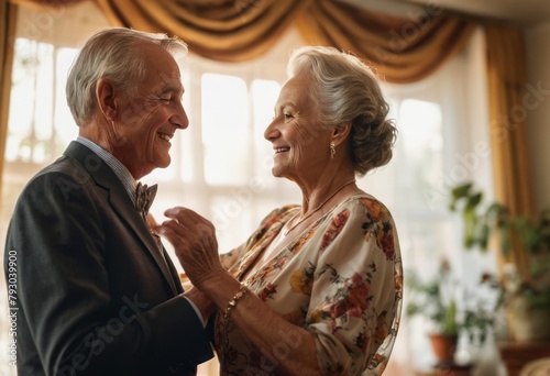 An elderly couple shares a dance at home. Joy and companionship shine through.