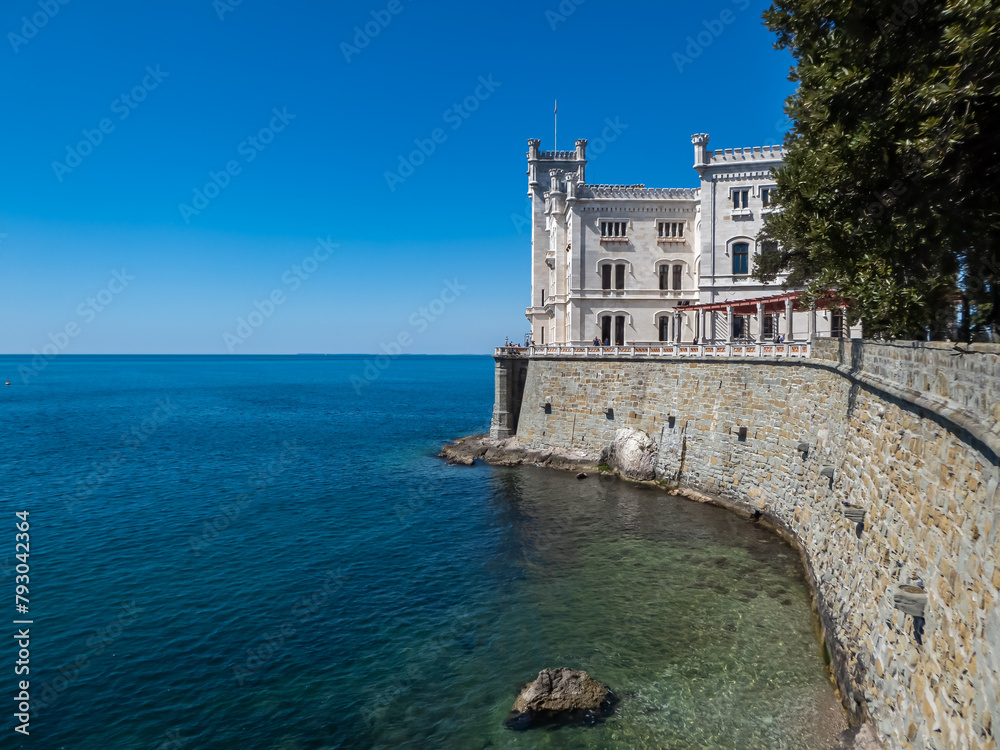 Scenic view of majestic historic white Miramare castle in Trieste in Friuli-Venezia Giulia, Italy, Europe. Blue sky in tranquil atmosphere at Adriatic Mediterranean sea in summer. Sightseeing
