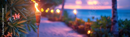 Blurry photo of a beach at sunset with tiki torches in the foreground photo