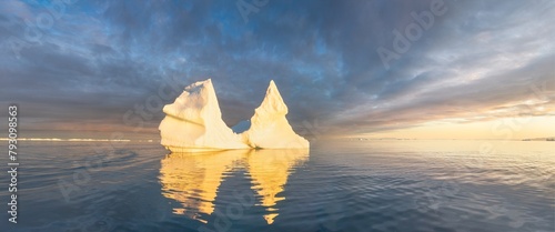 Iceberg at sunset. Nature and landscapes of Greenland. Disko bay. West Greenland. Summer Midnight Sun and icebergs. Big blue ice in icefjord. Affected by climate change and global warming.