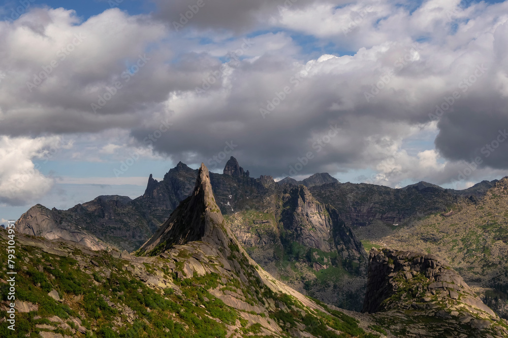 Fototapeta premium dramatic landscape with big pointy mountain peaks above low clouds