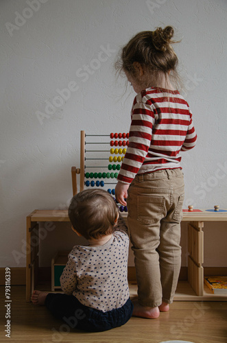 Un enfant et un bébé qui jouent dans une chambre d'enfant Montessori