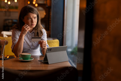 Woman trying to buy online. Woman holding credit card and having problem to buy online