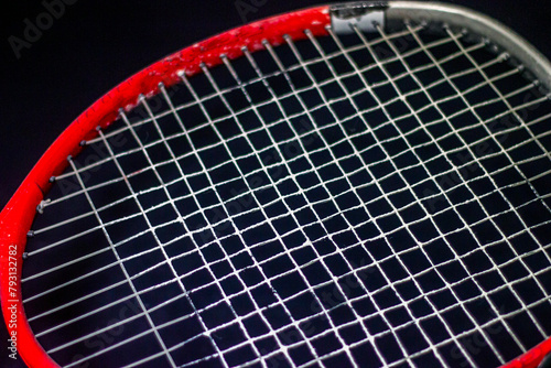 Red - gray racket with white strings on a black background © Vladimir Bartel