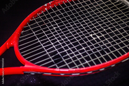 White powder on the strings of a red racket