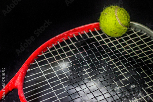 Green tennis ball lies on a tennis racket