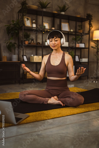 one japanese woman practice guided meditation at home use headphones