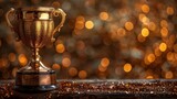 A low-key image of a trophy on a wooden table with dark background and abstract glitter lights