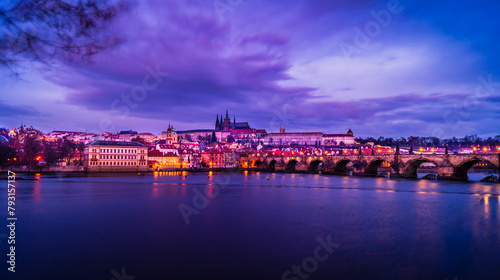 Twilight rosy evening sunset sky over the illuminated Prague Castle and Charles bridge seen towards the Lesser Quarter over the Vitava river in Prague, Czech Republic
