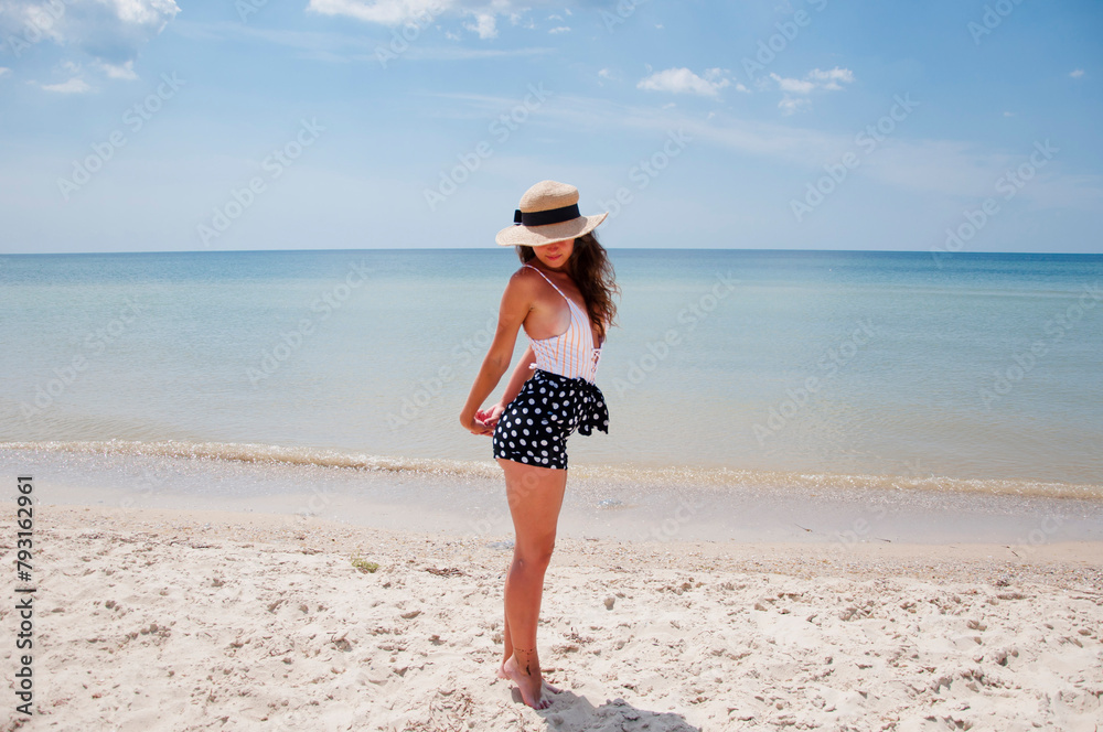 Woman on summer vacation at beach. Summer vacation of woman in swimsuit and straw hat. Retro woman at sea beach. Suntan at summer beach. Beach vacation of retro girl sunbathing. Sea travel resort Woman on summer vacation at beach. Summer vacation of woman in swimsuit and straw hat. Retro woman at sea beach. Suntan at summer beach. Beach vacation of retro girl sunbathing. Sea travel resort