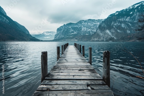  A wooden dock nestled in a body of water Mountains loom in the backdrop A cloudy sky stretches in the distance