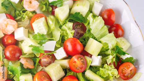A close-up salad of fresh vegetables, a plate of fresh salad with vegetables and herbs. Greek salad with juicy tomatoes, feta cheese lettuce leaves green olives cucumber, fresh parsley. Homemade food.
