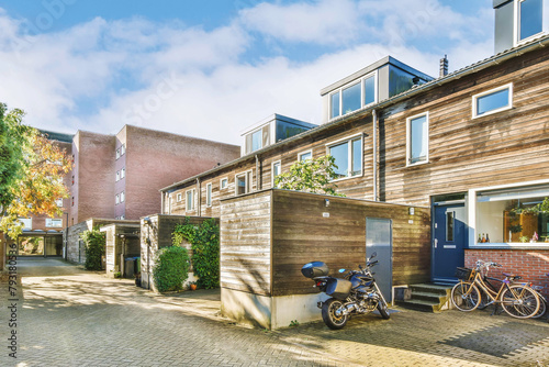 Modern townhouses with bicycles and a motorcycle parked outside photo
