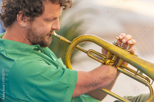 Passionate one-armed trumpet player performs outdoors photo
