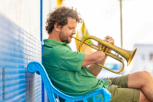 One-armed man playing trumpet in an urban setting photo