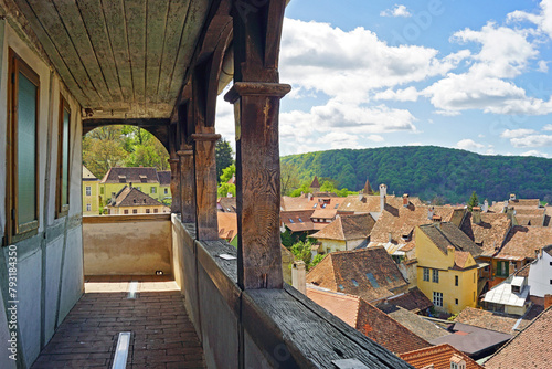 Landscape from the top level of the Clock Tower in the Romanian city of Sighisoara: a fragment of the old wooden gallery and a breathtaking view of the buildings in the Old Town