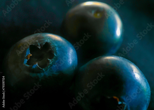 Macro of three blueberries with only one blossom end in focus with bokeh