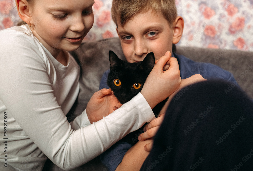Obraz premium Boy and Girl Holding Black Cat