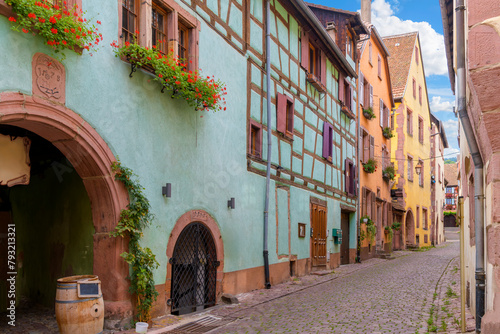Fototapeta Naklejka Na Ścianę i Meble -  Colorful half-timbered buildings with shops and cafes in the medieval old town of Riquewihr, France, one of France's 