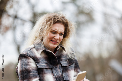 Woman is Frowns Using Cell Phone in Park
