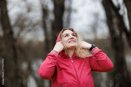 Woman in Jacket Holding Hoodie Over Head After Training .Outdoor