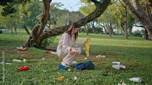 Girl park pollution cleanup collecting plastic organic waste from green grass. 