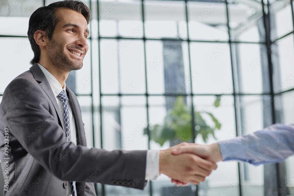 Handshake of two businessmen in the lobby of the modern business center Handshake of two businessmen in the lobby of the modern business center