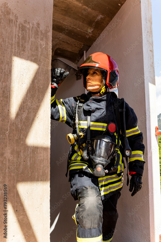Fototapeta premium An adult Caucasian woman works as a firefighter dressed in uniform.The senior woman is resting after climbing the stairs of a building.Concept of women in risky professions.