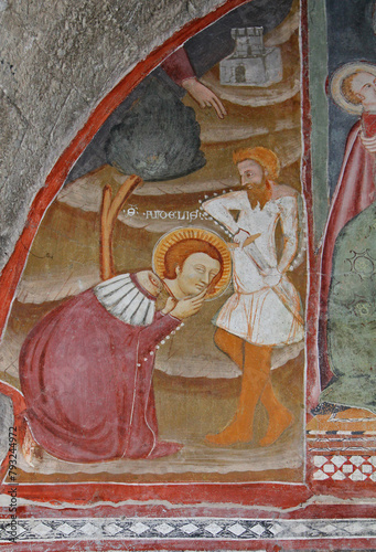 San Donnino decapitato regge la sua testa; affresco nella chiesa romanica di San Fedele a Como photo