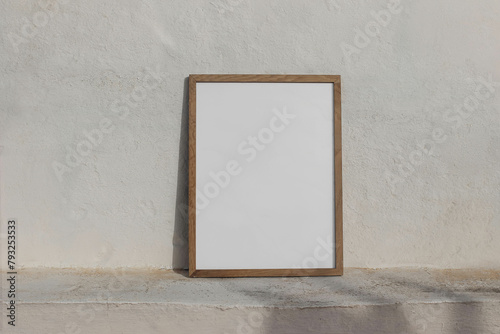 Minimal empty vertical wooden frame picture mockup against white old textured white wall in sunlight. A4, A3, A2 poster template. Neutral Summer background with light, shadows. Mediterranean design.