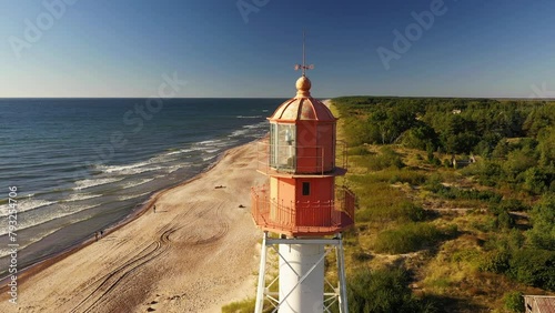 A landscape on the shore with a beautiful bright red lighthouse and a strong tide